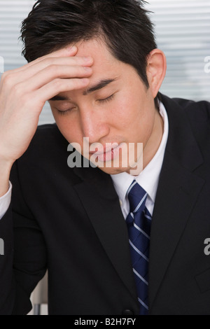 Nahaufnahme eines Kaufmanns unter Kopfschmerzen leiden Stockfoto