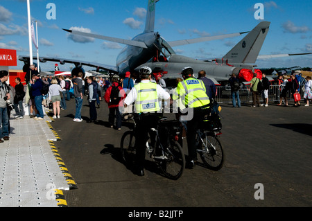 2 Polizisten auf Zuvorkommenheit in gelben Jacken sitzen sprechen bei einer öffentlichen Veranstaltung im Farnborough Air zeigen Weitwinkel Stockfoto