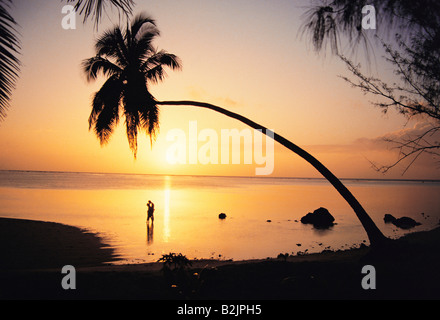 Cook Inseln. Silhouette von ein paar umarmt am tropischen Strand bei Sonnenuntergang. Stockfoto