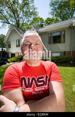 Hausbesitzer Posen vor seinem Haus trägt ein NASA-T-shirt Stockfoto