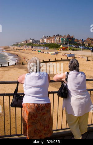 Menschen am Southwold Pier Look Out Over Strand an einem heißen Sommertag im Vereinigten Königreich Stockfoto