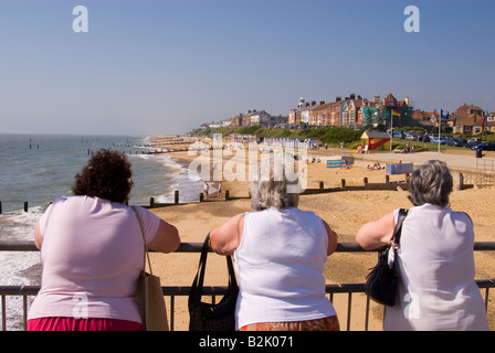 Menschen am Southwold Pier Look Out Over Strand an einem heißen Sommertag im Vereinigten Königreich Stockfoto