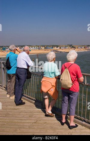 Menschen am Southwold Pier Look Out Over Strand an einem heißen Sommertag Stockfoto