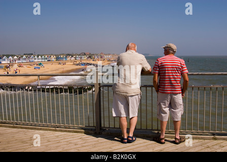Menschen am Southwold Pier Look Out Over Strand an einem heißen Sommertag Stockfoto