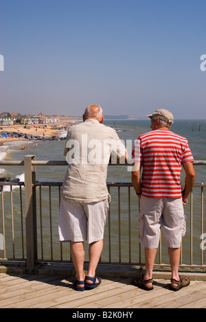Menschen am Southwold Pier Look Out Over Strand an einem heißen Sommertag Stockfoto