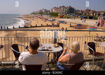 Menschen am Southwold Pier Look Out Over Strand an einem heißen Sommertag Stockfoto