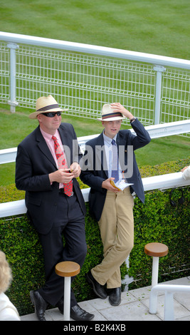 Glorious Goodwood: Vater und Sohn tragen Panamahüte am Ladies' Day in der Gewinner-Gehäuse. Stockfoto