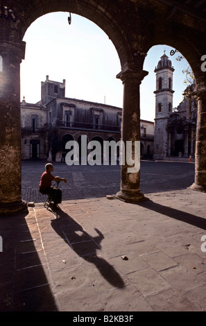 Einsamer Mann sitzt auf einem Stuhl unter einen der Bögen des Domplatzes in Havanna, Kuba Stockfoto