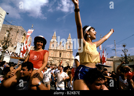 Mann, jubelnde Frau auf seinen Schultern trägt, während eines Festivals, malta Stockfoto