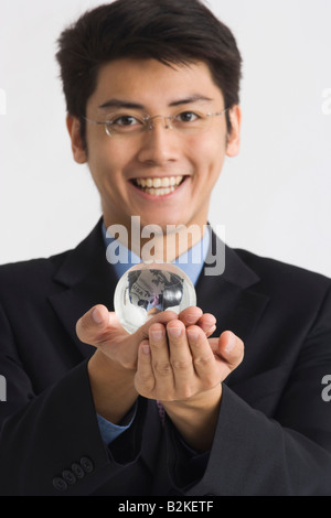Porträt eines Geschäftsmannes hält einen Globus und lächelnd Stockfoto