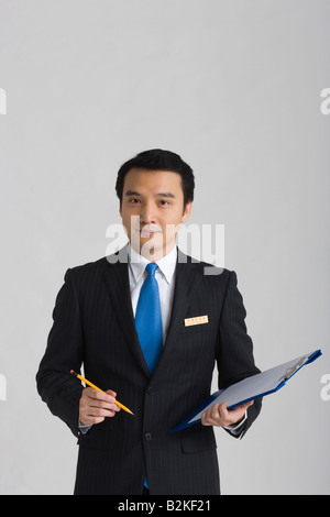 Porträt eines Geschäftsmannes hält einen Stift und ein Klemmbrett Stockfoto