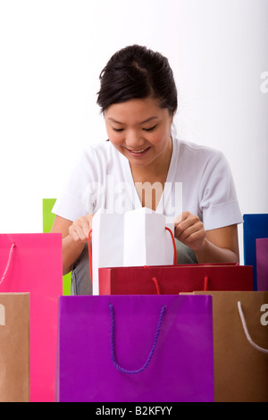Junge Frau, die in eine Einkaufstasche Stockfoto