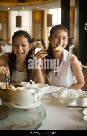 Zwei junge Frauen, die Dim Sum in einem Restaurant Essen Stockfoto