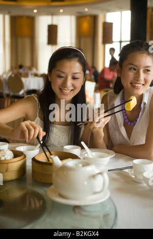 Zwei junge Frauen, die Dim Sum in einem Restaurant Essen Stockfoto