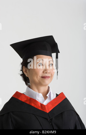 Nahaufnahme der Reife weibliche Absolventin eine Graduierung Kleid tragen und lächelnd Stockfoto