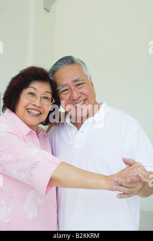 Porträt von ein älteres paar tanzen und Lächeln Stockfoto