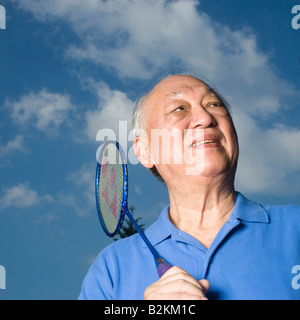 Niedrigen Winkel Blick auf ein senior Mann hält einen Badminton-Schläger Stockfoto
