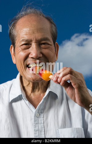 Porträt eines älteren Mannes ein Eis essen und lächelnd Stockfoto