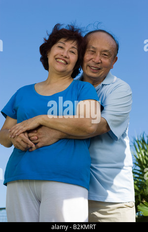 Porträt eines senior eine reife Frau von hinten umarmt und lächelnd Stockfoto