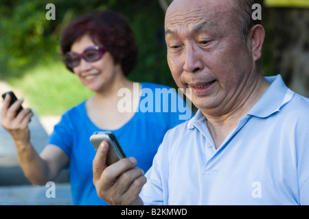 Senior Woman und eine reife Frau, Blick auf Handys Stockfoto