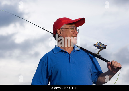 Nahaufnahme von einem senior Mann hält eine Angelrute und lächelnd Stockfoto