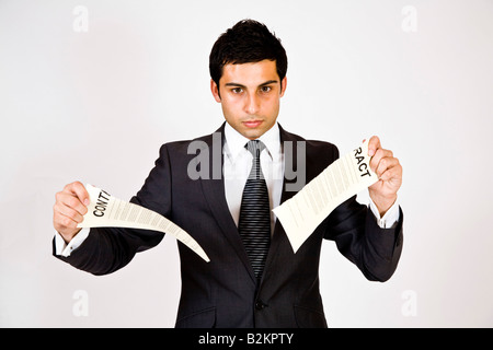 Ein Mann in einem Anzug, einen Vertrag zu zerreißen. Stockfoto