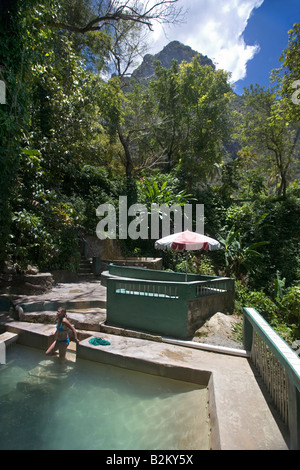 Eine Frau badet in Heißwasser Mineral Bäder in der Nähe der Pitons im Hintergrund im südlichen St Lucia gehört Stockfoto