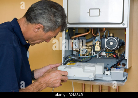 Mann arbeitet auf einen Gas-Brennwertkessel Stockfoto