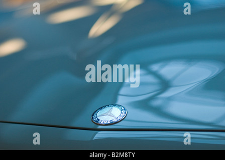 Das Logo auf der Motorhaube von einem blauen Mercedes-Benz 230 SL Stockfoto