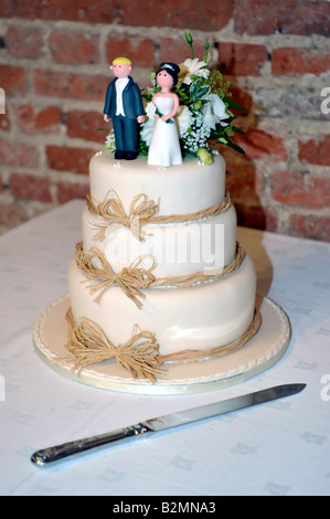 Hochzeitstorte mit humorvollen Figuren der Braut und des Bräutigams Stockfoto