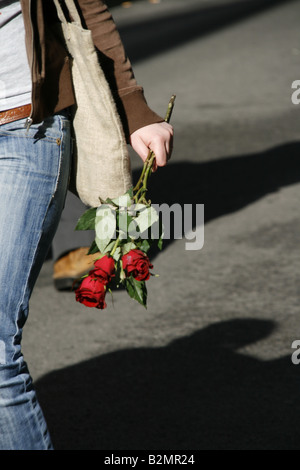 Detail der Frau mit drei roten Rosen in der Stadt Stockfoto