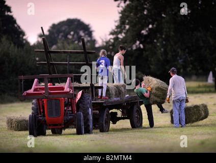 EINE BAUERNFAMILIE SAMMELN HEU IM TRADITIONELLEN STIL IN GLOUCESTERSHIRE UK Stockfoto