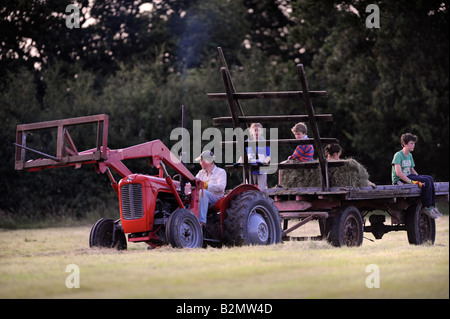 EINE BAUERNFAMILIE SAMMELN HEU IM TRADITIONELLEN STIL IN GLOUCESTERSHIRE UK Stockfoto