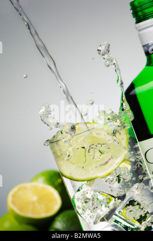 Ich mache einen Gin Tonic. Abgewinkelte Aufnahme von Tonic-Wasser, das aus einer Höhe in ein geradliniges Hi-Ball-Glas gegossen wird, wodurch es spritzt. Stockfoto