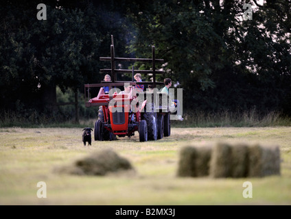 EINE BAUERNFAMILIE SAMMELN HEU IM TRADITIONELLEN STIL IN GLOUCESTERSHIRE UK Stockfoto