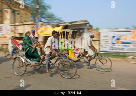 Zwei Fahrradrikschas und Passagiere in Varanasi.  Langsame Verschlusszeit und schwenken für Bewegung verwischen. Stockfoto