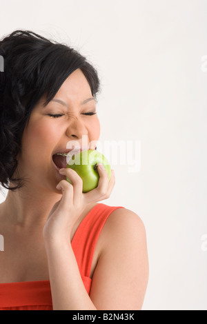 Nahaufnahme einer jungen Frau, die einen Apfel essen Stockfoto