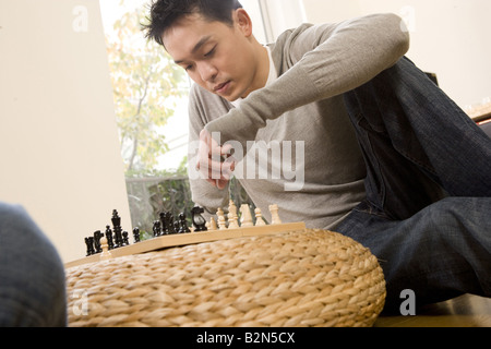 Blick auf einen jungen Mann spielt Schach Stockfoto