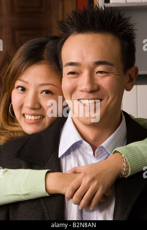 Porträt von eine Geschäftsfrau, die einen Geschäftsmann von hinten umarmen Stockfoto