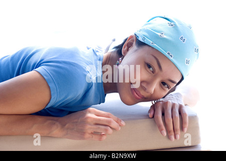 Nahaufnahme einer jungen Frau auf dem Bett liegend und lächelnd Stockfoto