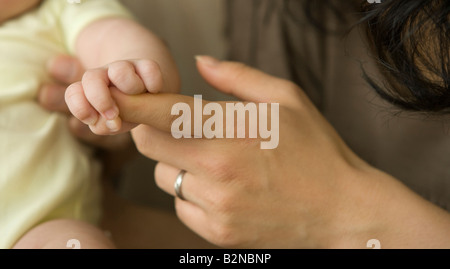 Babymädchen hielt ihre Mutter seiner hand Stockfoto