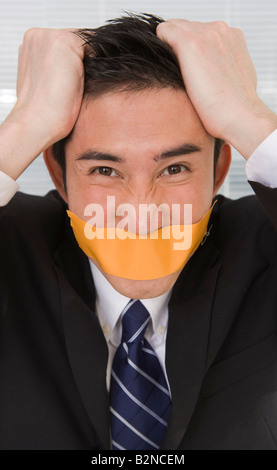Porträt eines Geschäftsmannes mit Klebeband auf seine Lippen und seine Haare Stockfoto