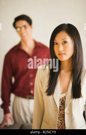 Porträt einer jungen Frau mit einem jungen Mann, der hinter ihr stehenden Stockfoto