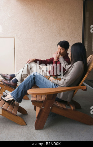 Junger Mann küssen eine junge Frau Hand in einen Balkon Stockfoto