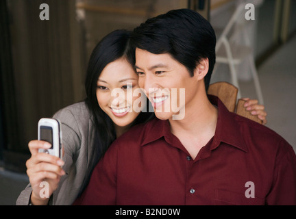 Nahaufnahme eines jungen Paares, ein Bild von sich selbst mit einem Mobiltelefon und lächelnd Stockfoto