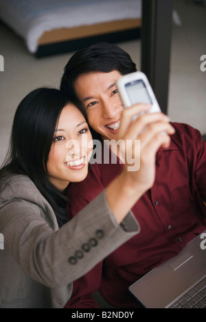 Nahaufnahme eines jungen Paares, ein Bild von sich selbst mit einem Mobiltelefon und lächelnd Stockfoto
