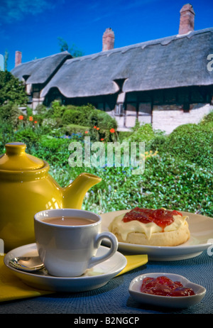 Sahne Tee Marmelade Creme & Scone mit Anne Hathaways strohgedeckten Hütte und Garten im Hintergrund. Stratford-upon-Avon England Großbritannien Stockfoto