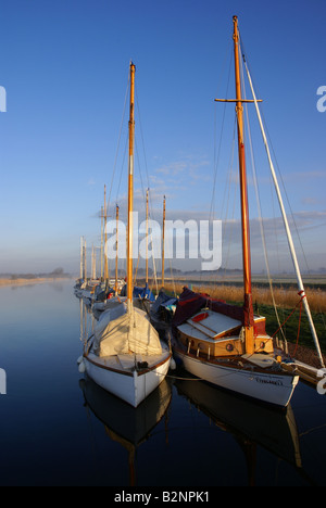 Sonnenaufgang auf der Norfolk Broads, blauer Himmel und Nebel.  Vertäuten Broads Yachten mit Markisen auf. Stockfoto