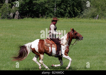 Ein Cowboy im Galopp über ein Feld Stockfoto