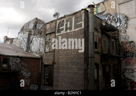 New York NY 3. August 2008 - alte Graffiti bedeckt Chinatown Mietskasernen mit einer Satellitenschüssel Stockfoto